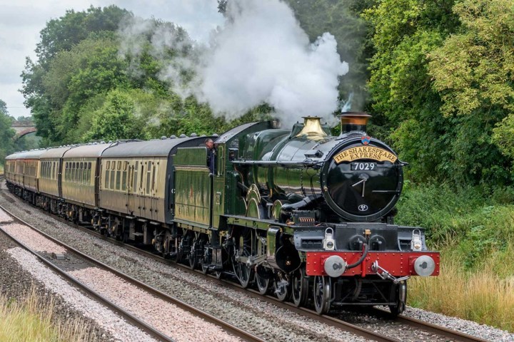a steam train on a track with smoke coming out of it