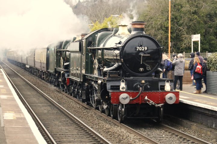 a steam engine is sitting on a train track