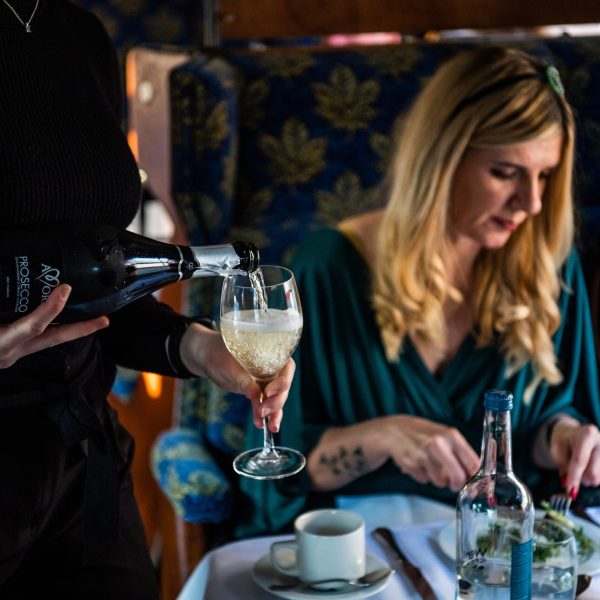 a woman sitting at a table with wine glasses