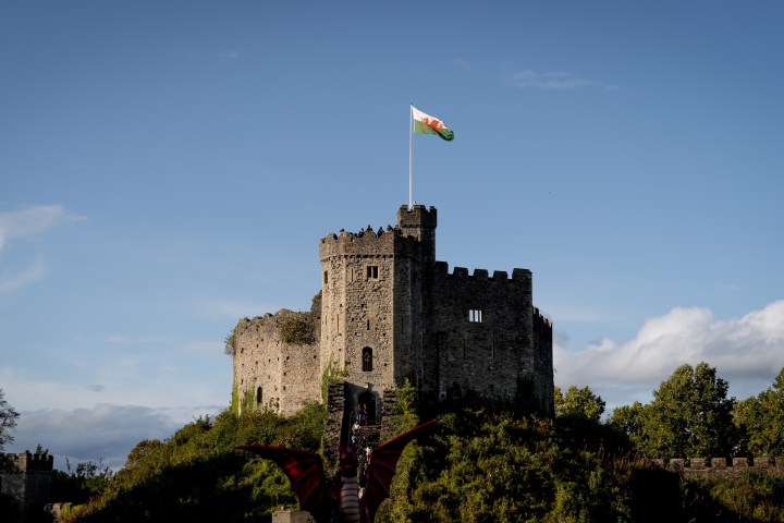 a castle with a clock tower with Cardiff Castle in the background