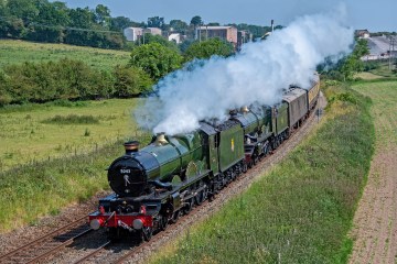 a steam train on a track with smoke coming out of it