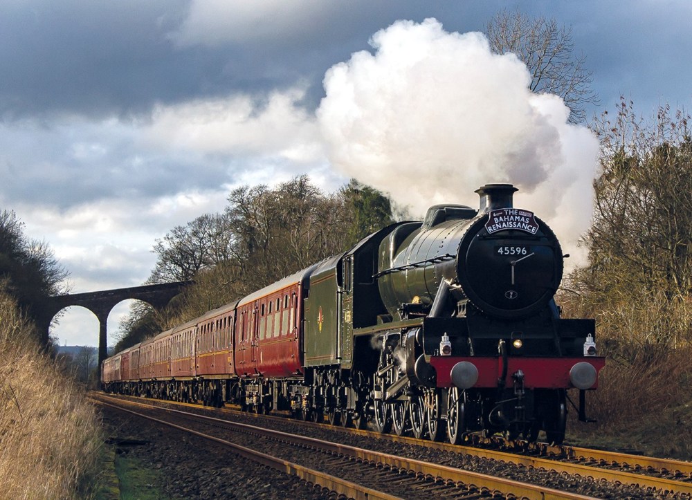 a steam engine train traveling down train tracks