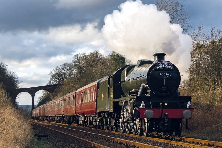 a steam engine train traveling down train tracks