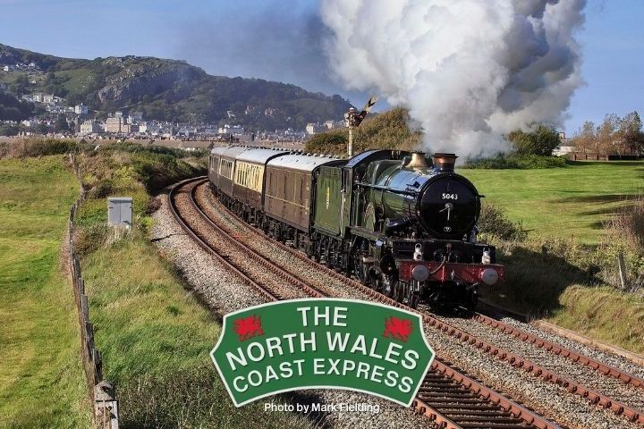 Steam train labeled 'The North Wales Coast Express' travels through countryside.