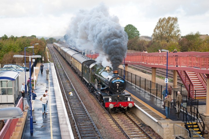 a steam train on a track with smoke coming out of it