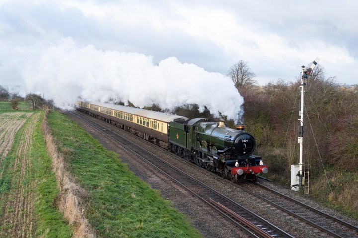 a steam train on a track with smoke coming out of it