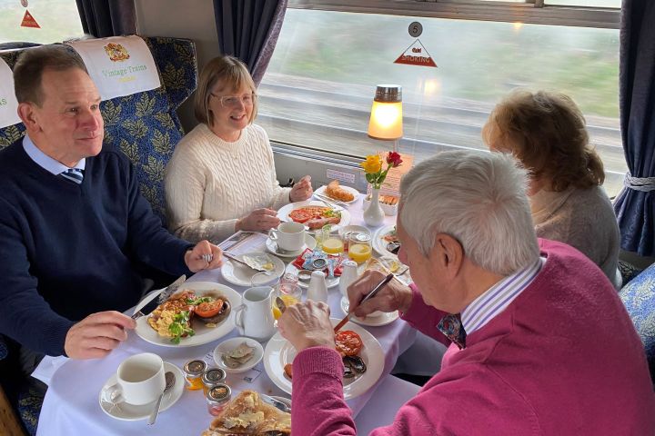 a group of people sitting at a table eating food