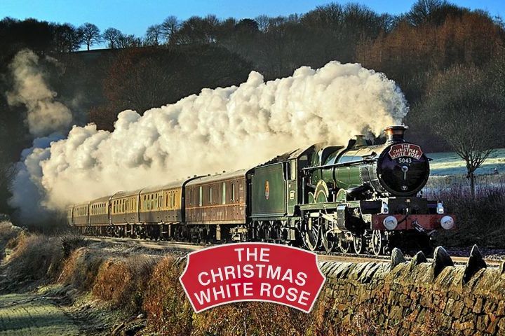 Steam train with sign 'The Christmas White Rose' traveling through frosty countryside.