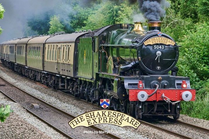 Steam train named 'The Shakespeare Express' passing through green countryside.
