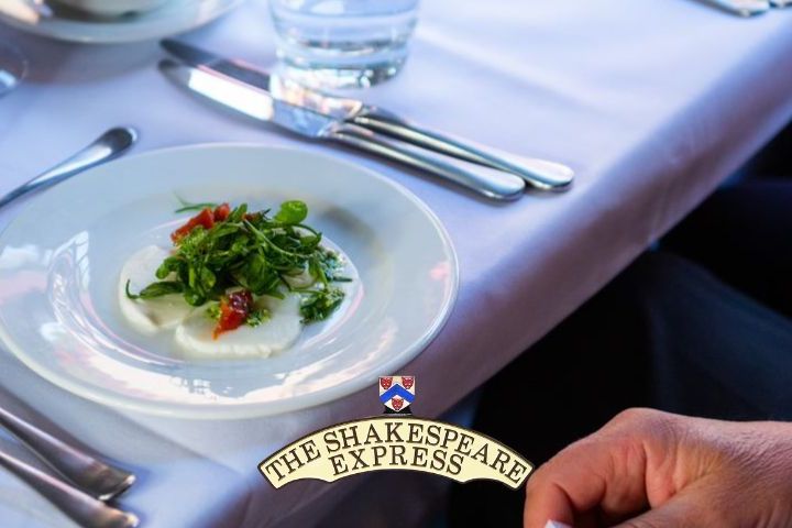 Elegantly set dining table with a starter dish and company logo.
