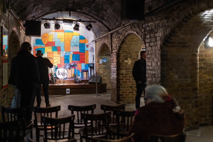 Underground venue with chairs, stage, and colorful map mural.