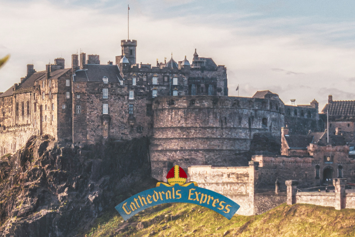 Historic castle on a hill with a blue and gold 'Cathedrals Express' sign in front.